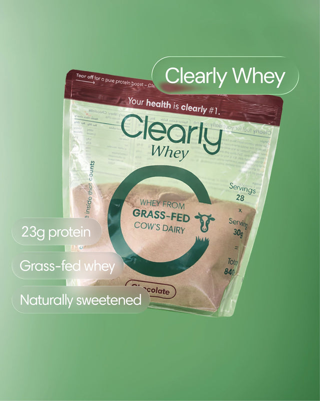 Clearly Grass-fed Whey protein powder jar with a scoop, showing the front label and a white powder inside.